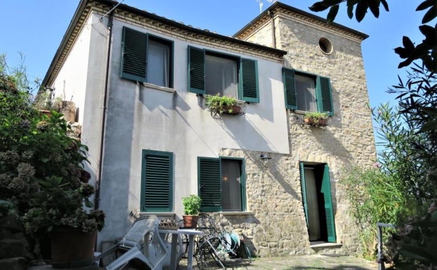 stone property in Italy with green shutters