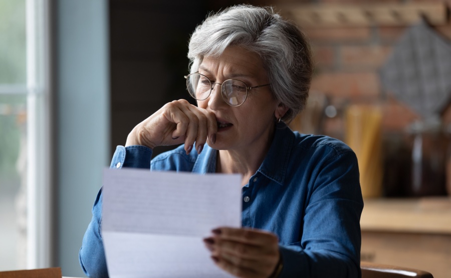 A woman looks with concern at a financial document