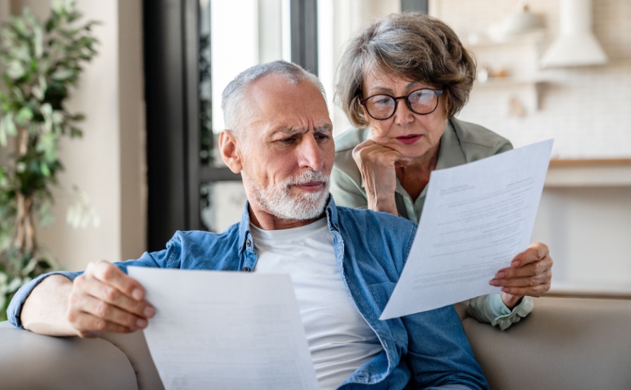 Man and woman look concerned at financial paperwork