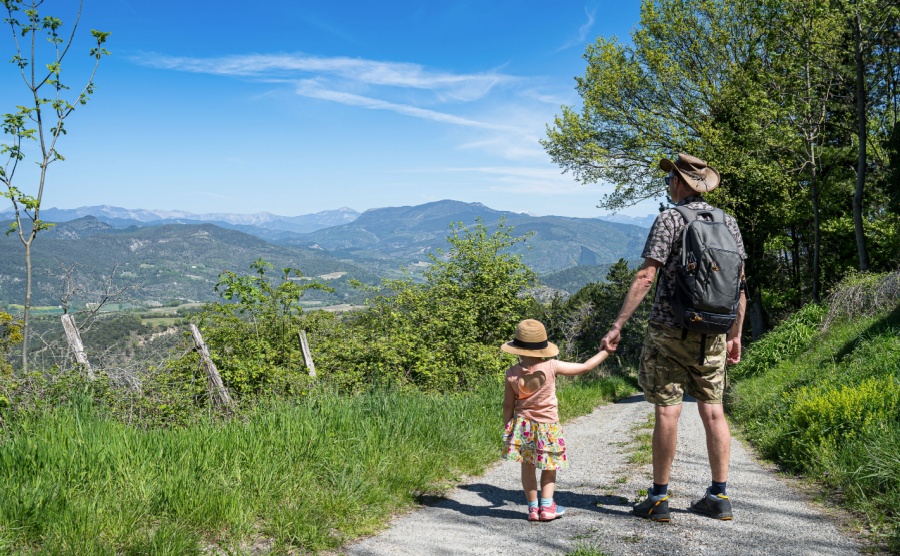 Dad and his little girl hiking in French Drome region and enjoying the view off Vercors mountains during summer season