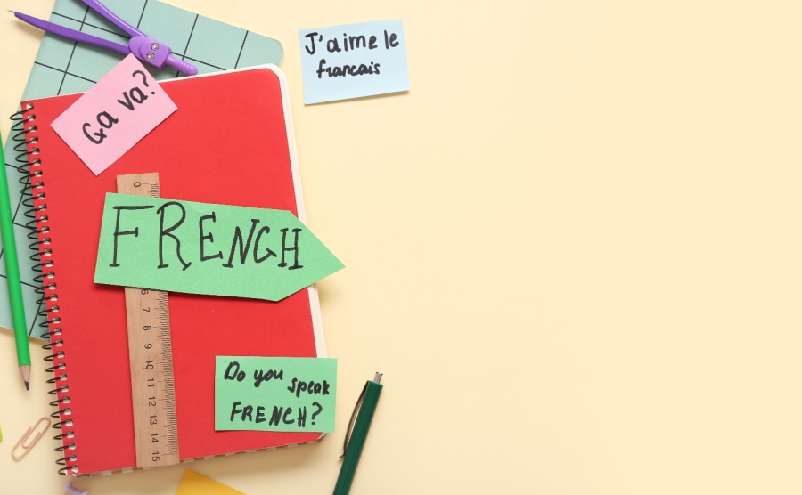 French phrases and stationery on beige background with space for text
