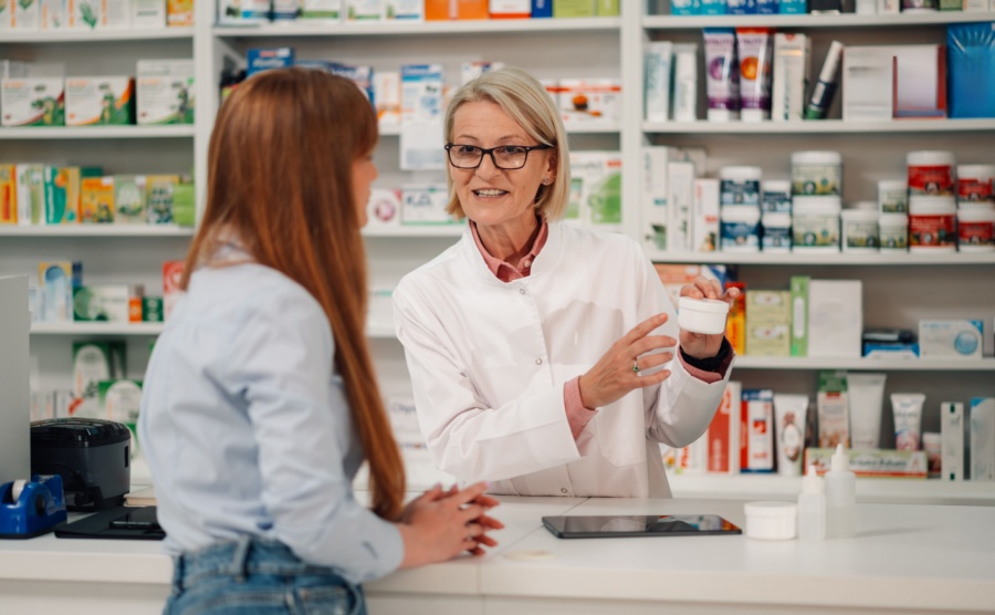Portrait of professional female senior pharmacy store worker standing behind counter at apothecary