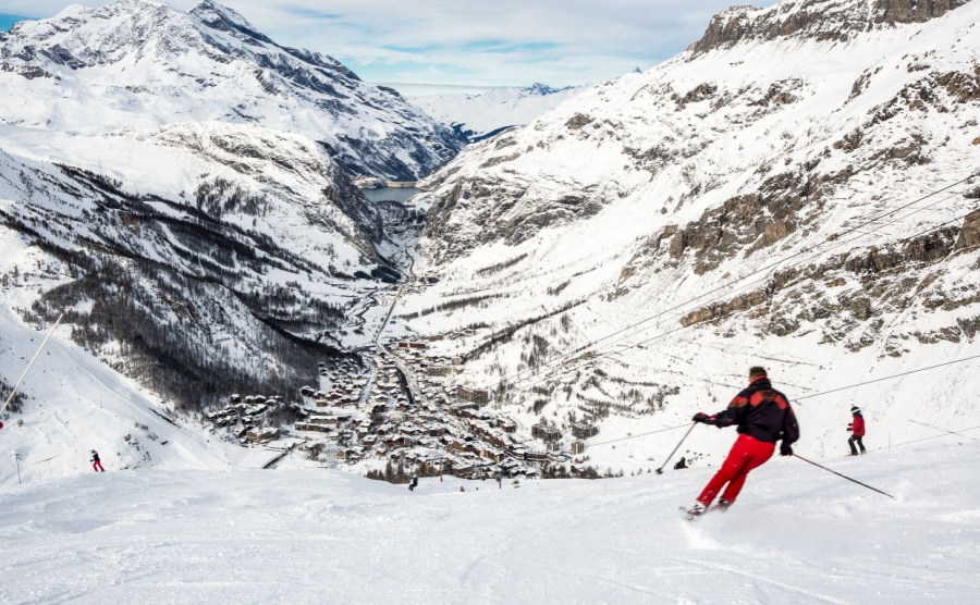 Skiers on the piste with the village of Val d isere on the background