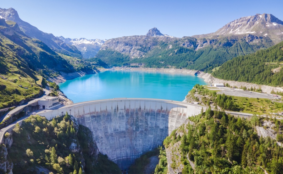 Water dam and reservoir lake aerial view in Alps mountains in summer generating hydroelectricity