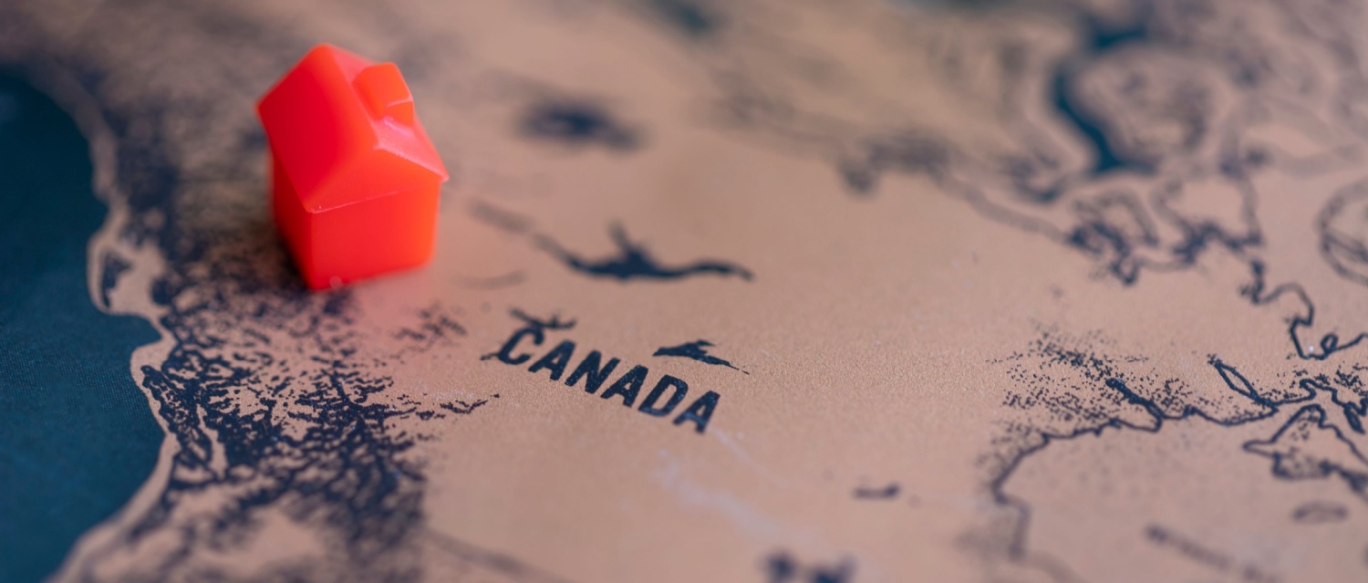 A monopoly house on a map of canada