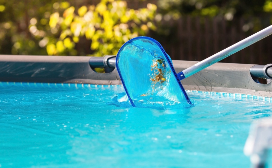 A person cleaning their pool with a net