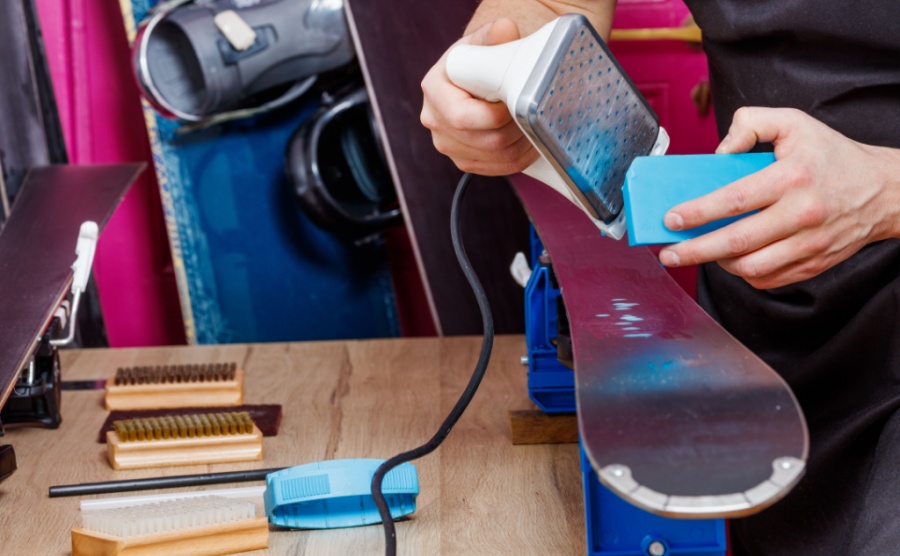 A worker applying wax to a set of skis