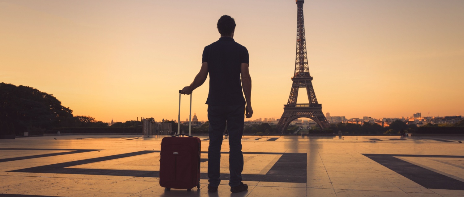 tourist in Paris looking at Eiffel Tower silhouette of man with luggage travel to France
