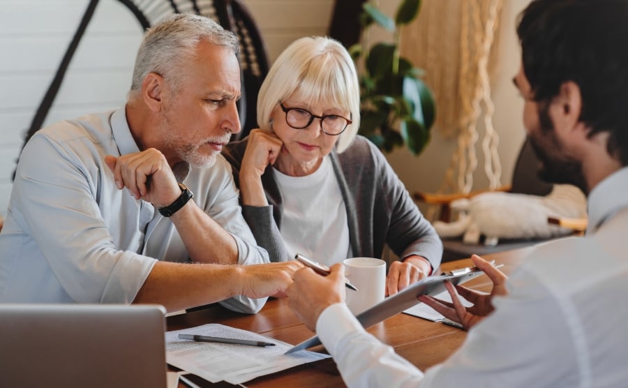 Senior couple consulting lawyer about house purchase