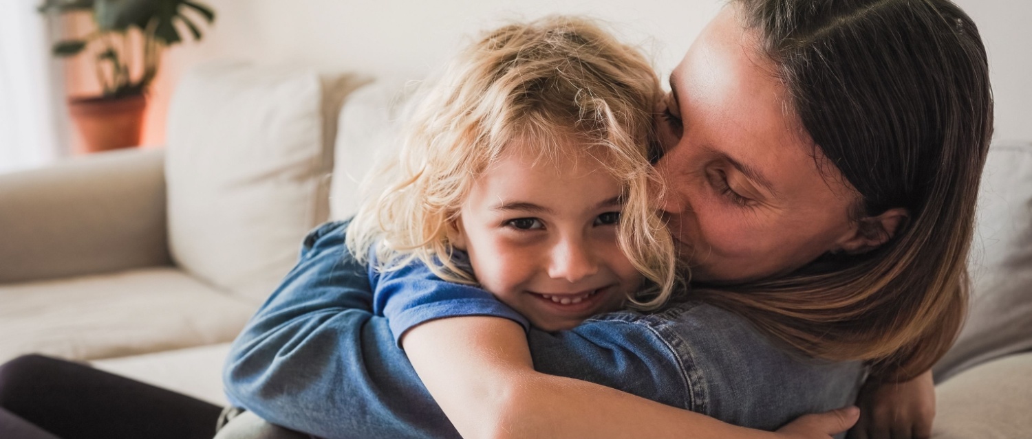 Happy mother and son hugging each other and having fun at home - Family love concept - Soft focus on mom head