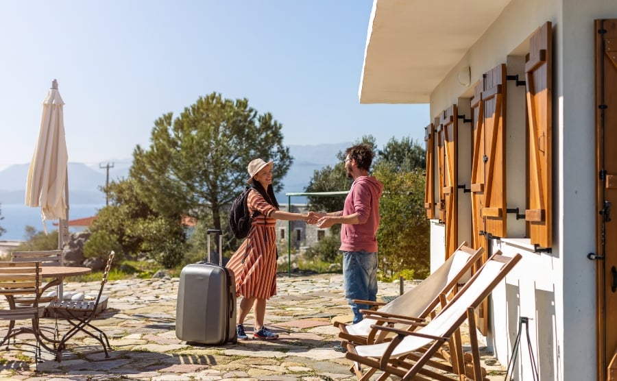 Woman and man shaking hands outside holiday home