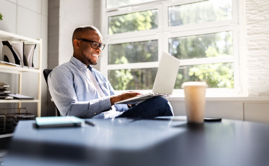Successful African American Businessman Leading Team in Analyzing Market Trends and Utilizing Technology in Modern Office Setting