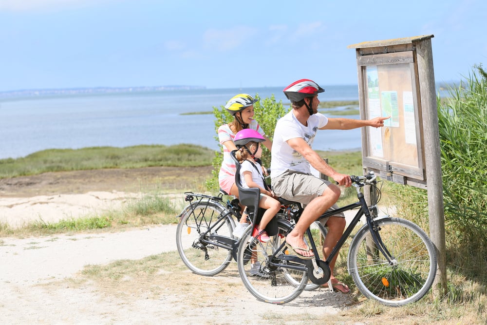 Family of three on a biking day looking at map