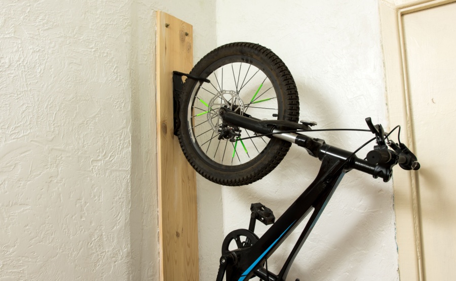 A mountain bike hanging from a wall mount in a holiday home