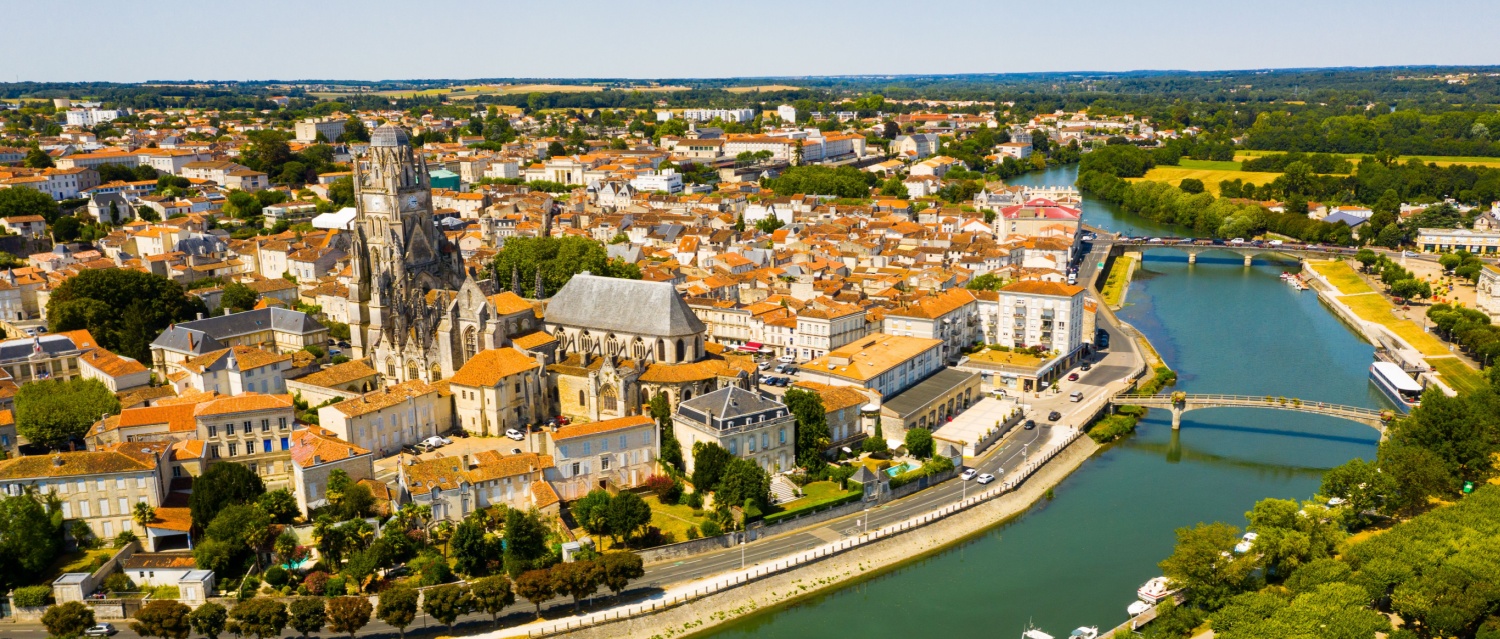 Picturesque summer view of historic areas of Saintes located on Charente river looking out over cathedral bell tower in Flamboyant Gothic style, Charente-Maritime, France.