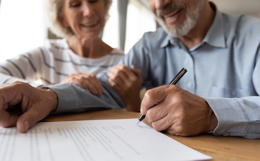 Smiling couple signing document