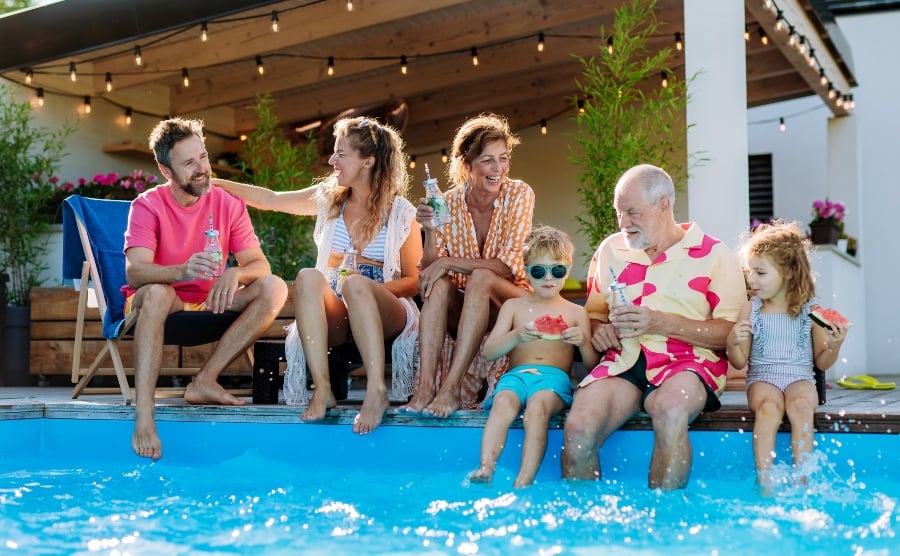 Family dipping their feet in a swimming pool
