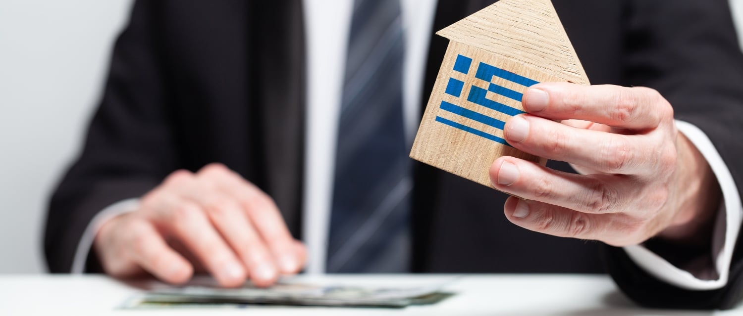 Taxman holding house with Greek flag