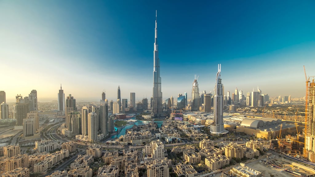 Modern skyscrapers and low-rise traditional architecture surround the fountains in Downtown Dubai.