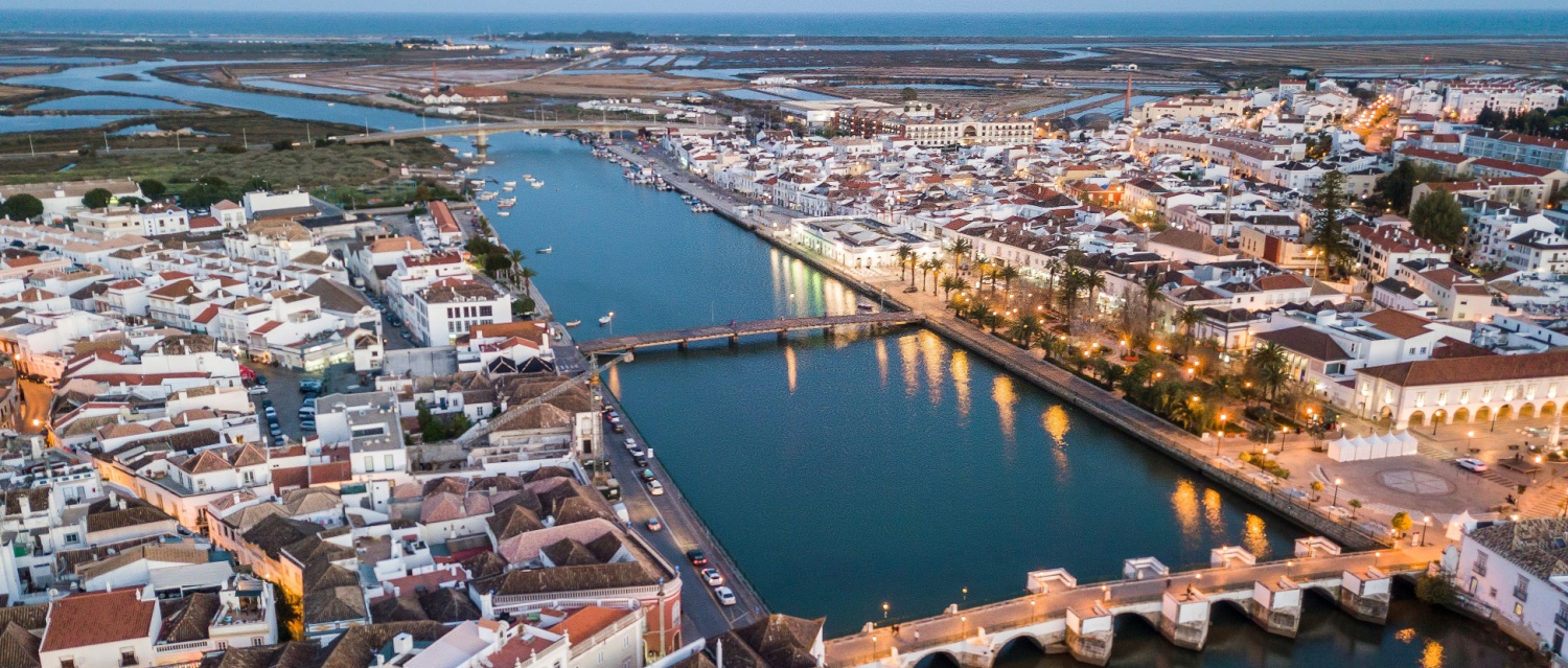 Aerial cityscape of beautiful Tavira with roman bridge over Gilao river in the evening, Algarve, Portugal