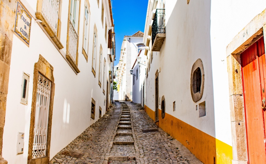 Picturesque cobbled alleyway and old buildings on either side. Tavira, Algarve, Portugal