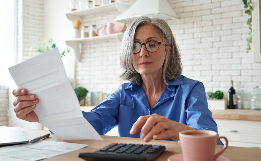 Senior woman at kitchen table with tax bill