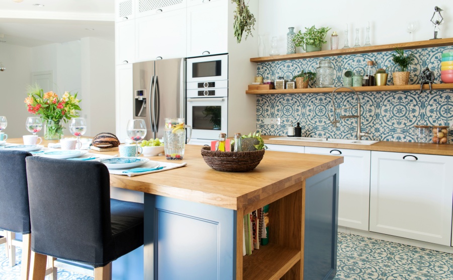 Stylish and sunny kitchen interior with accessories, wooden table and plants. Design space.