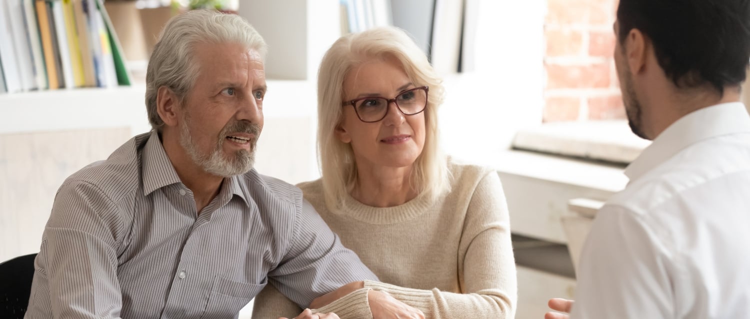 Senior couple talking to a professional man across a desk