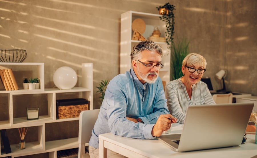 Senior couple looking at laptop screen
