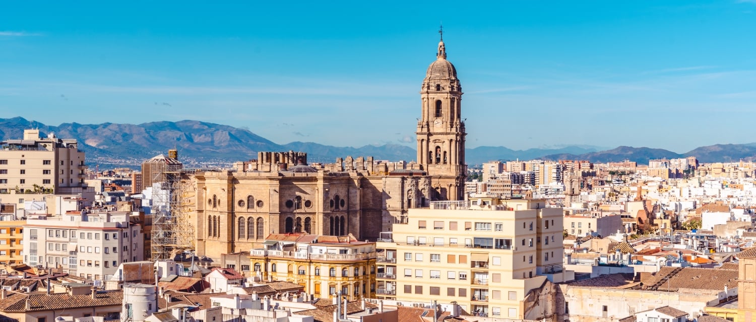 Malaga Cathedral and buildings with mountains