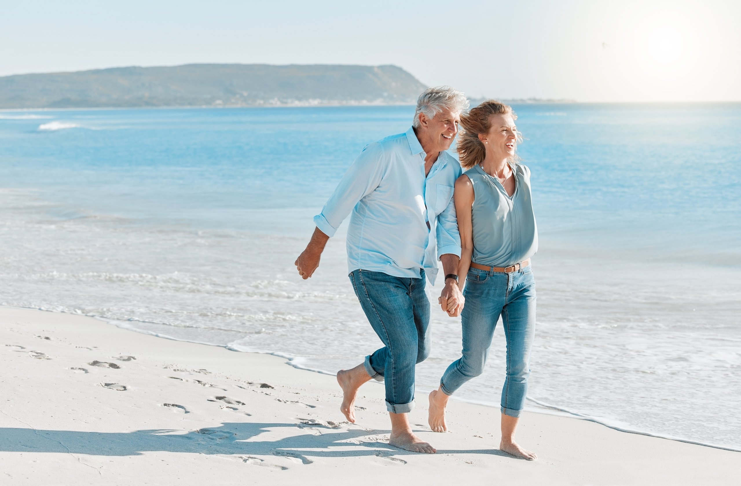 Happy couple holding hands on beach