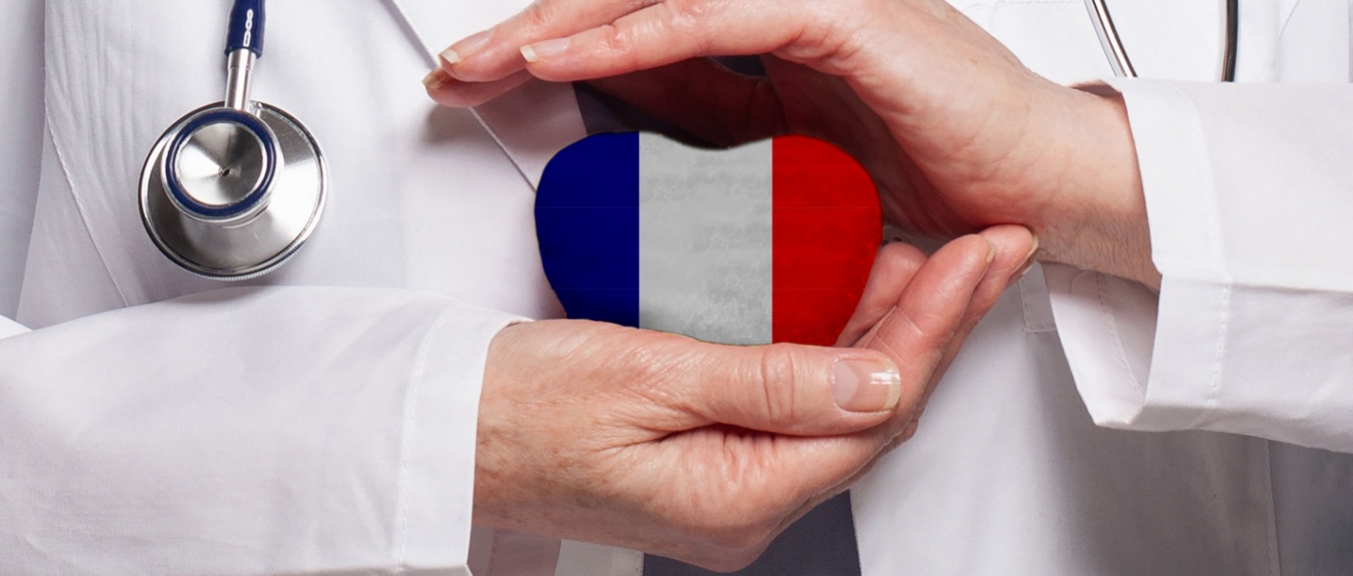 French doctor holding heart with flag of France background. Healthcare, charity, insurance and medicine concept