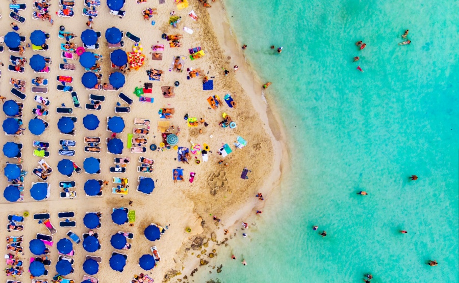 Amazing Aerial View from Above over Nissi Beach in Cyprus. Nissi Beach At high tide. Tourists relax on the beach. Crowded beach with lots of tourists. A popular place