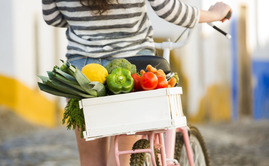 Beautiful female tourist living like a local, with her bicycle after buying some fresh vegetables