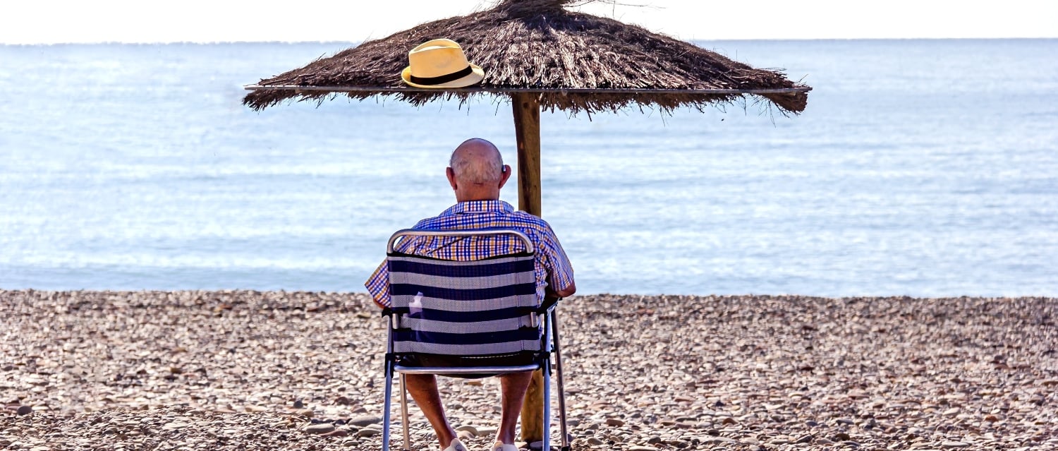 Man under a parasol on the beach