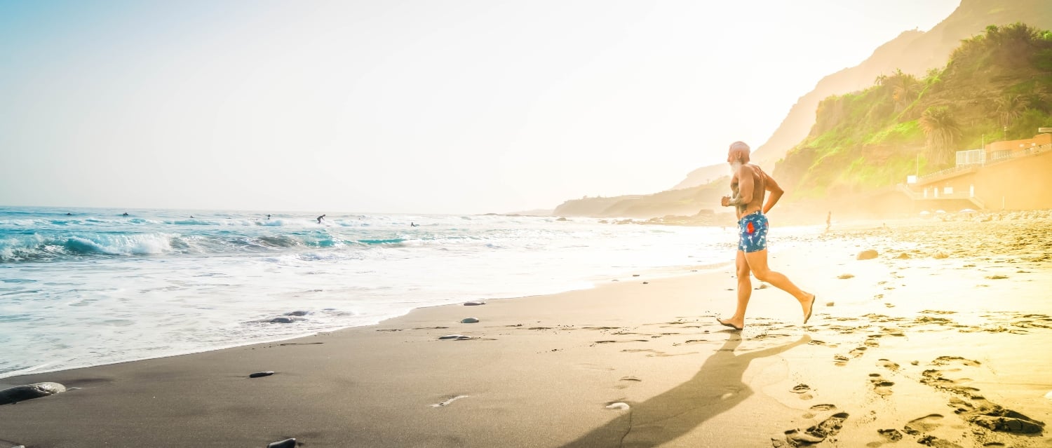 Senior man running towards the sea