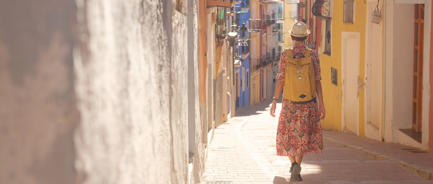 Woman walking down a colourful Spanish street