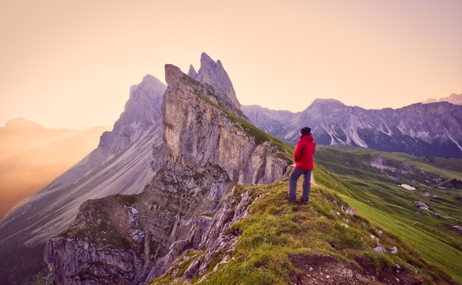 Amazing view on Seceda peak. Trentino Alto Adige, Dolomites Alps, South Tyrol, Italy Europe. Odle mountain range, Val Gardena. Majestic Furchetta peak in morning sunlight. Man traveler traveling alone