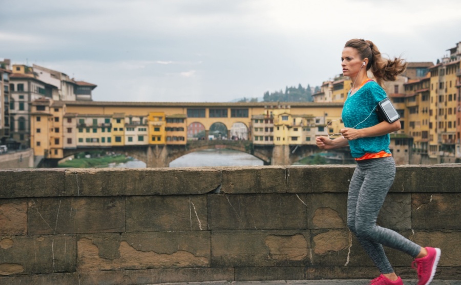 Fitness woman jogging in front of Ponte Vecchio in Florence, Italy