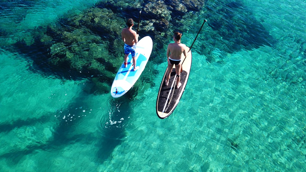 Two male paddleboarders in turquoise sea