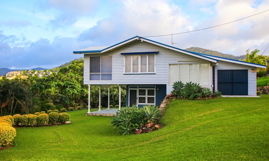 House on stilts surrounded by lush grass