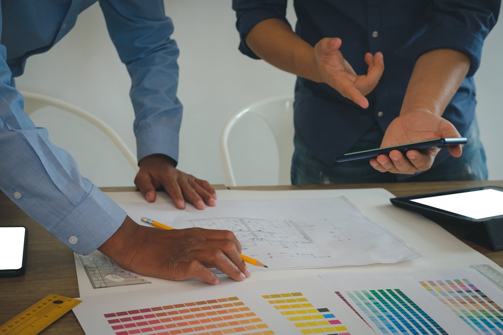 People looking at a house plan and colour swatches