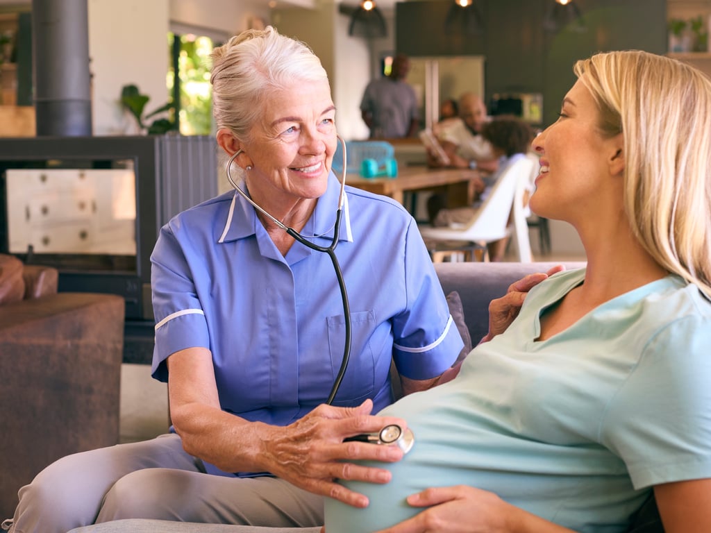 Midwife with hand on pregnant woman's belly
