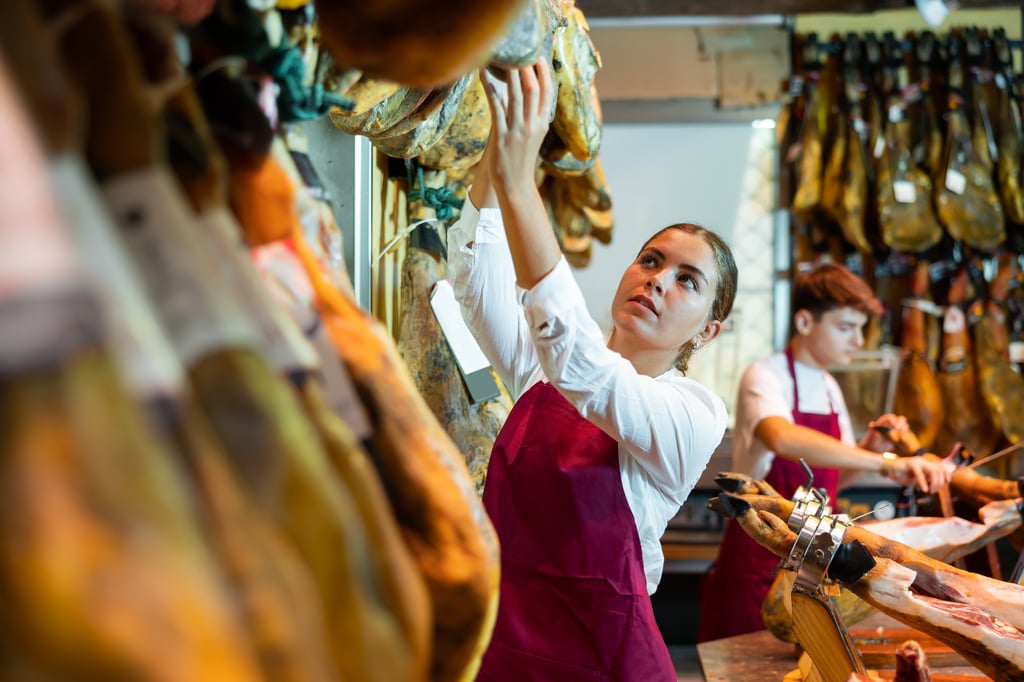 Couple cutting ham in a butcher shop