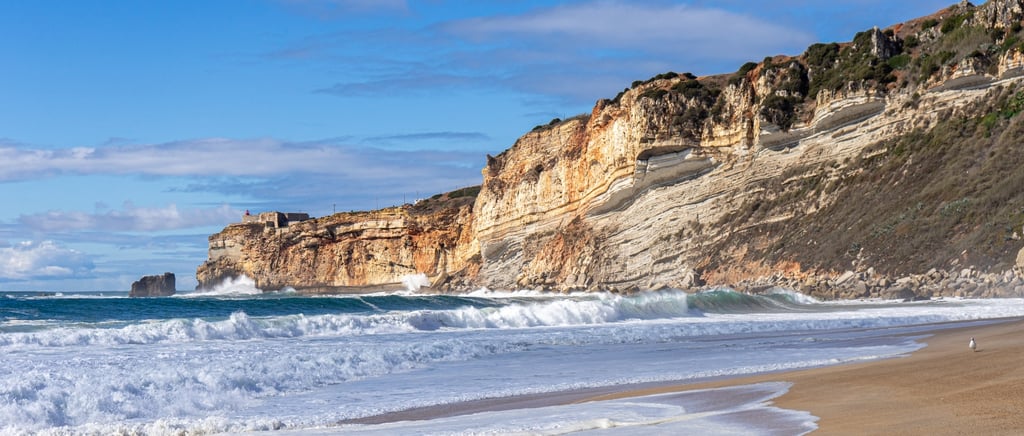 View along the Silver Coast cliffs near Nazaré with the Atlantic Ocean and sandy beach below, Portugal