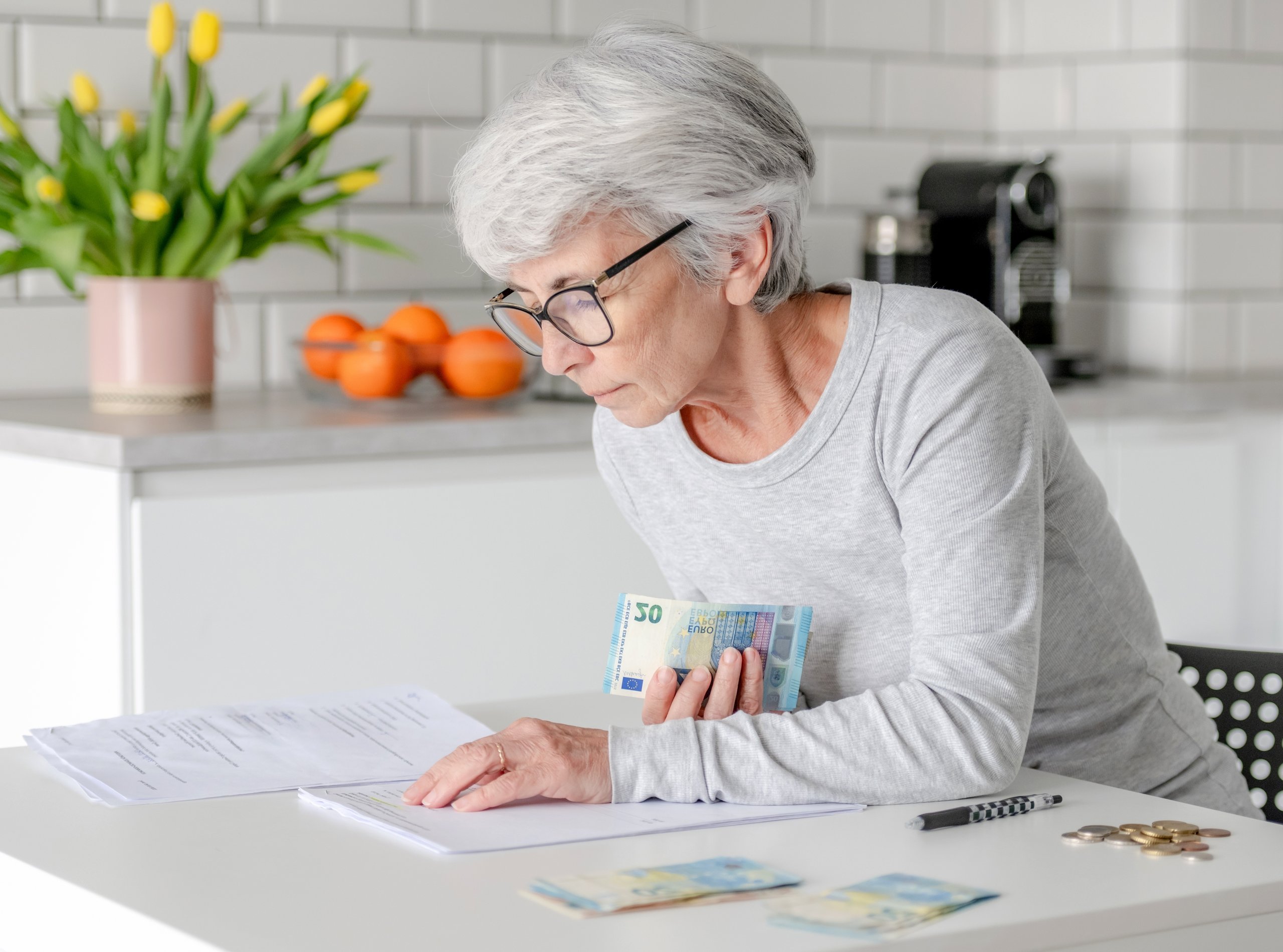 Senior woman holding cash and paperwork