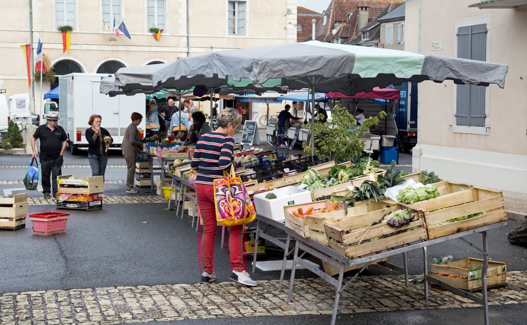 Fresh produce laid out on a market stall in a French village square