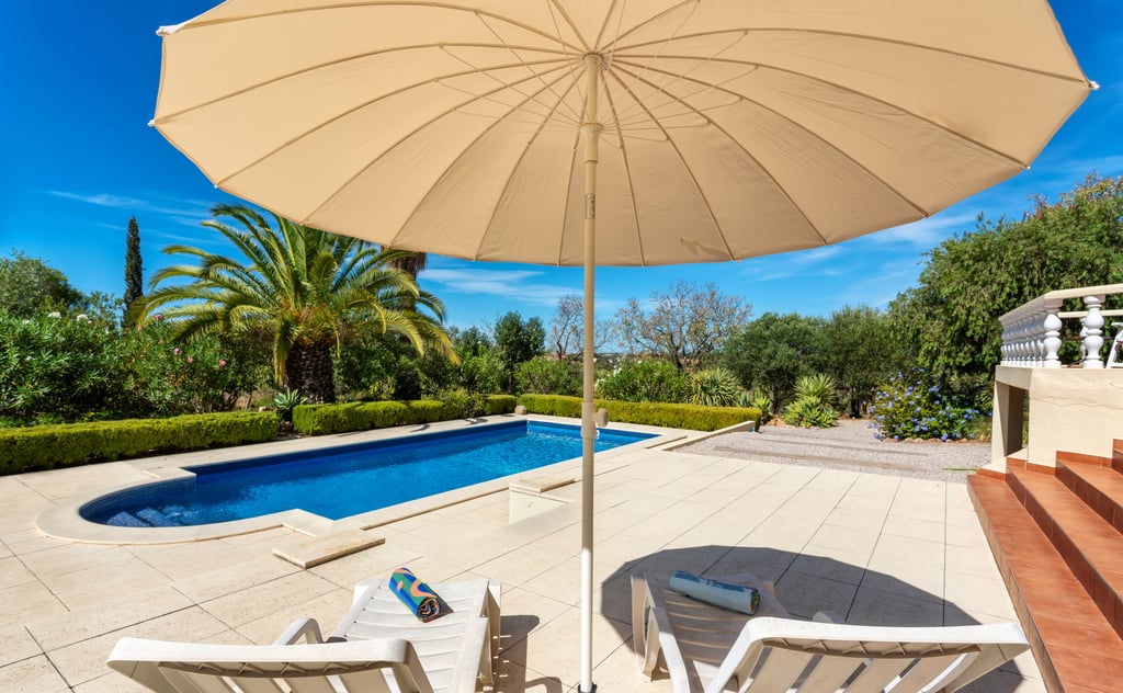 Swimming pool and landscaped garden at a villa in the Algarve, Portugal, showing the kind of outdoor space that requires regular maintenance