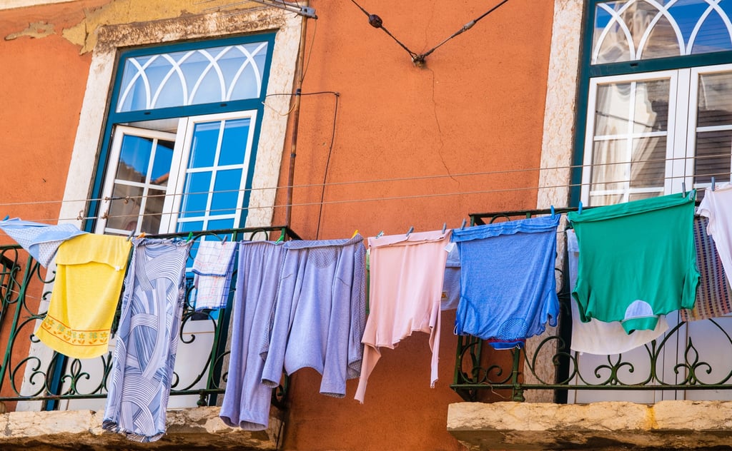 Apartment balcony with terrace furniture overlooking a Portuguese town, showing a typical two-bedroom property with modest running costs