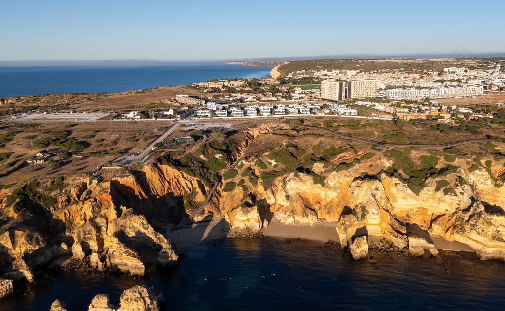 Golden sandstone cliffs and turquoise sea at Praia Dona Ana in Lagos, one of Portugal's best beach towns for retirees